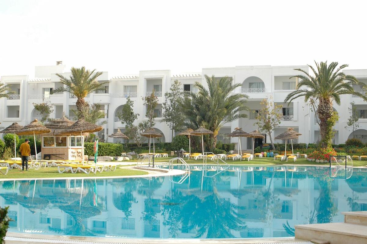 Resort pool surrounded by palm trees in Hammamet Sud, Tunisia