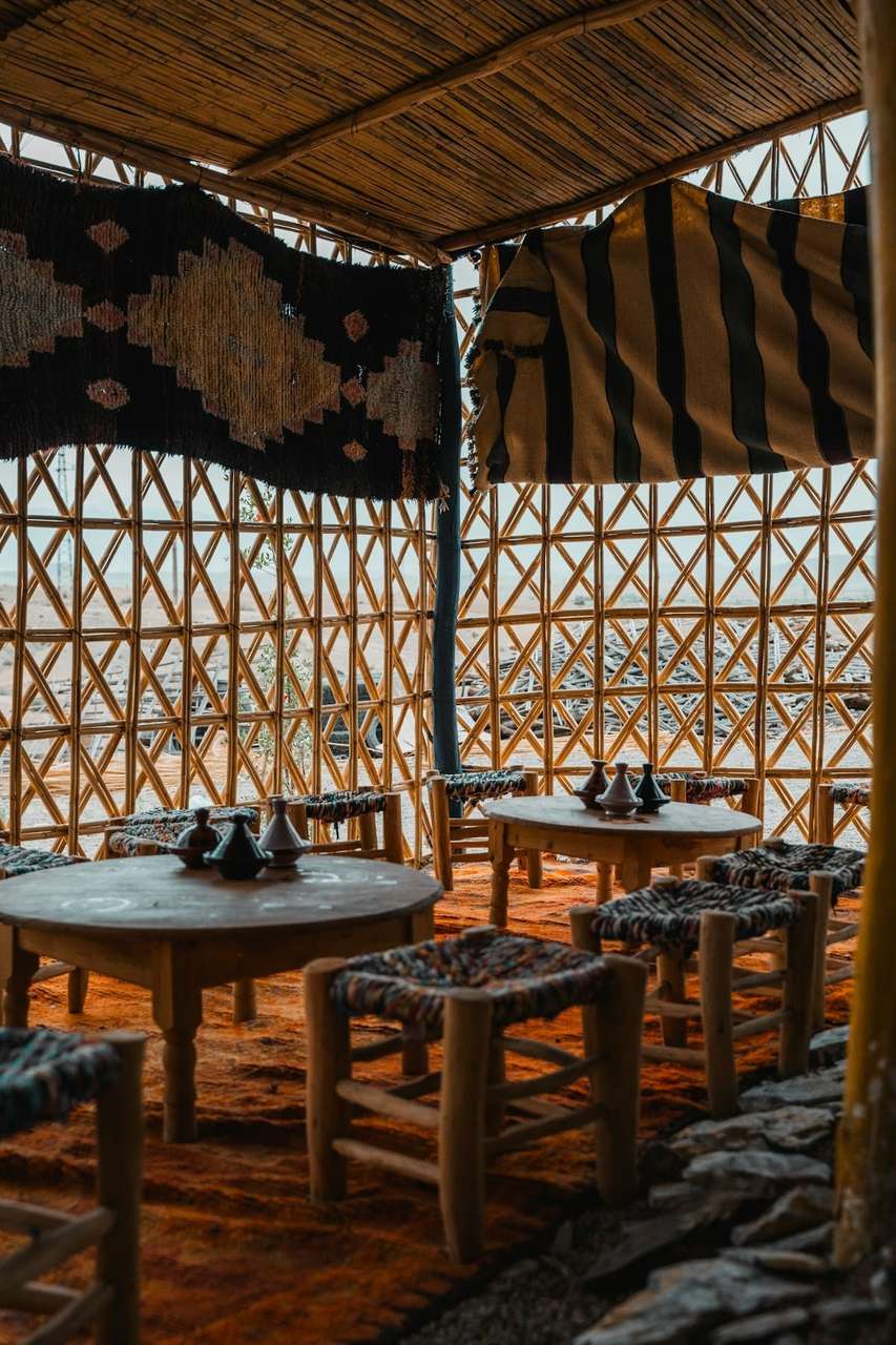 Traditional cafe interior with woven reed walls, wooden stools and tribal textile decor, Tunisia