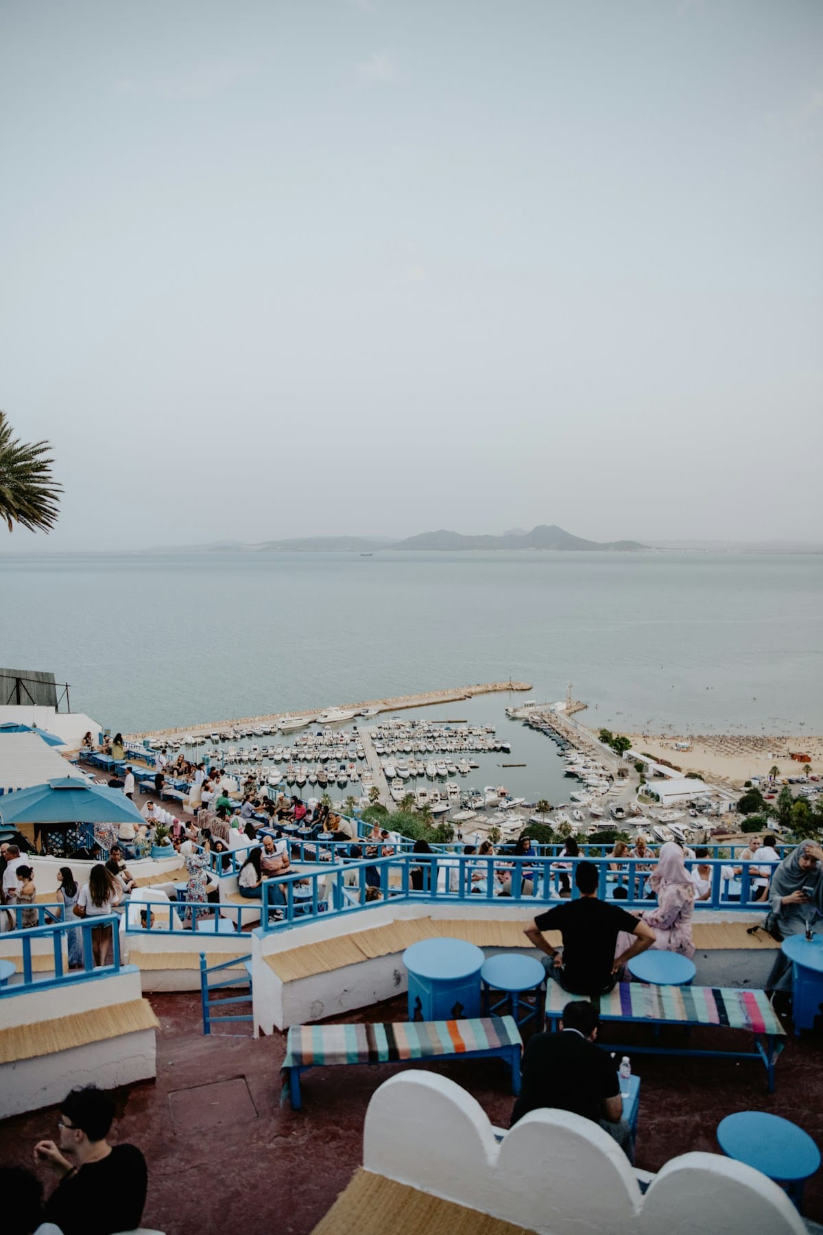 Outdoor terrace restaurant with sea views and blue-and-white Mediterranean decor, coastal Tunisia