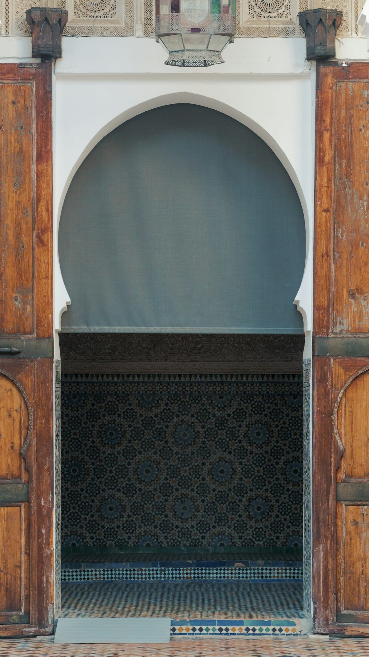 Arche ornée avec carrelage décoratif et portes en bois, intérieur de bain traditionnel en Afrique du Nord
