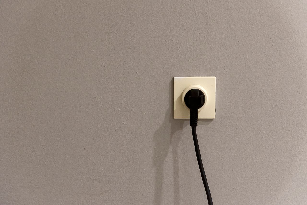 European round-pin wall socket with a black plug, typical of Tunisian power outlets