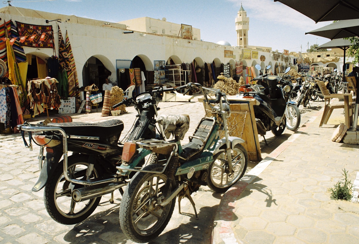 Busy street with motorcycles and shops in a Tunisian medina — safety and scams guide