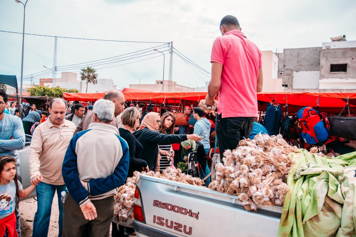 Busy outdoor market in Tunis with vendors and locals buying fresh produce, Tunisia
