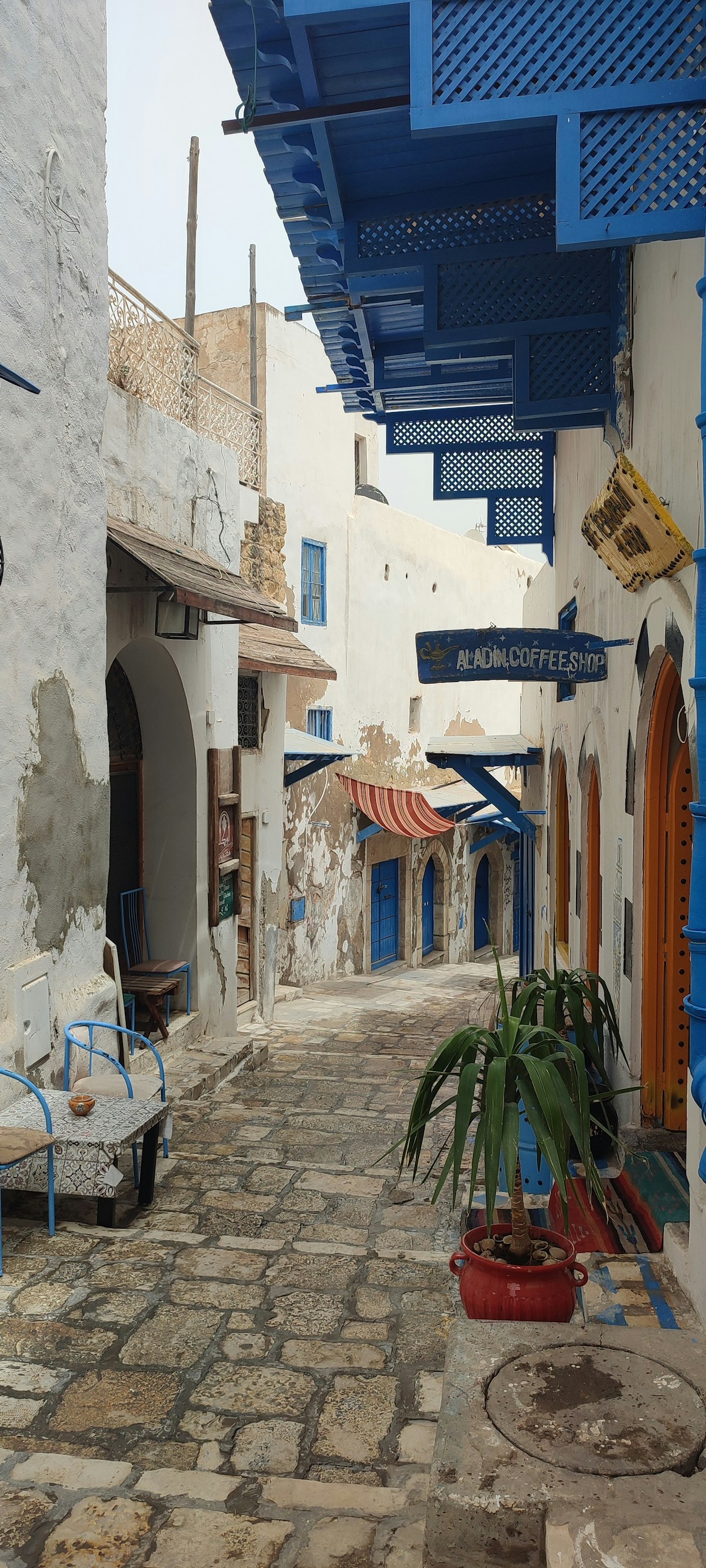 Narrow cobbled street with blue wooden balconies in the Sousse Medina, Tunisia
