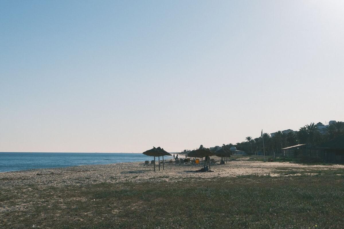 Quiet beach with thatched umbrellas on the Tunisian coast