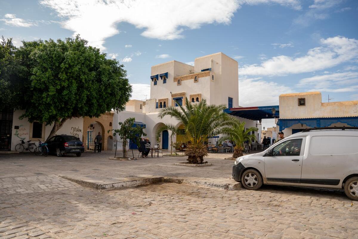 Place ensoleillée avec palmiers et maisons blanchies à la chaux à Djerba, Tunisie
