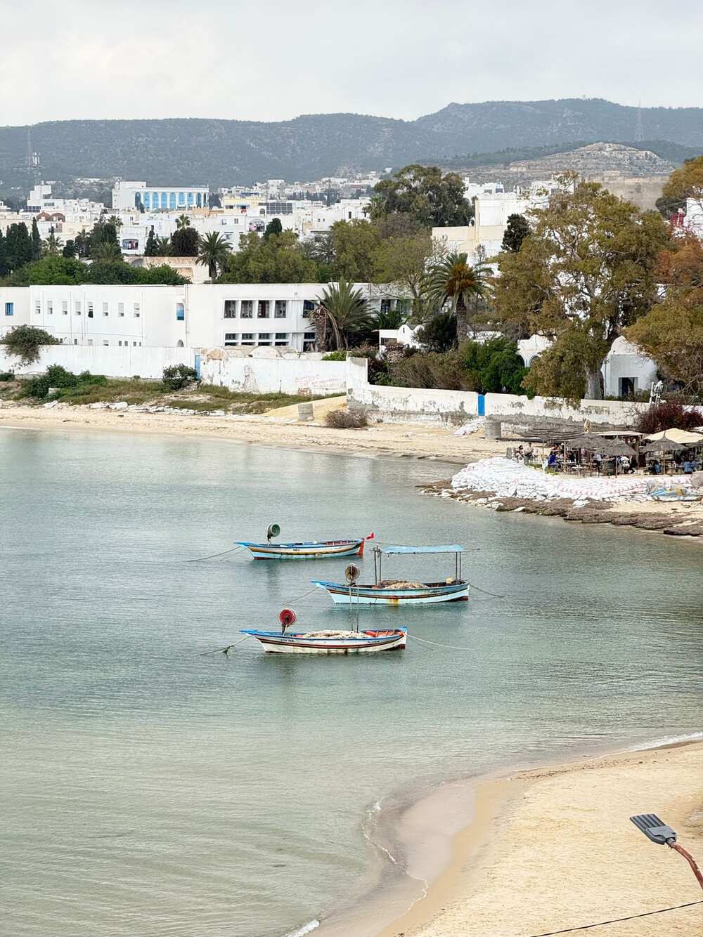 Barques traditionnelles dans la baie de Hammamet avec la ville en arrière-plan, Tunisie