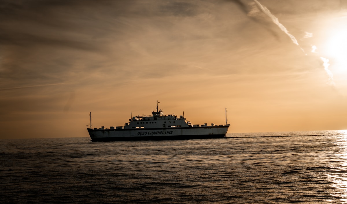 A ferry boat sailing across the Mediterranean Sea at sunset