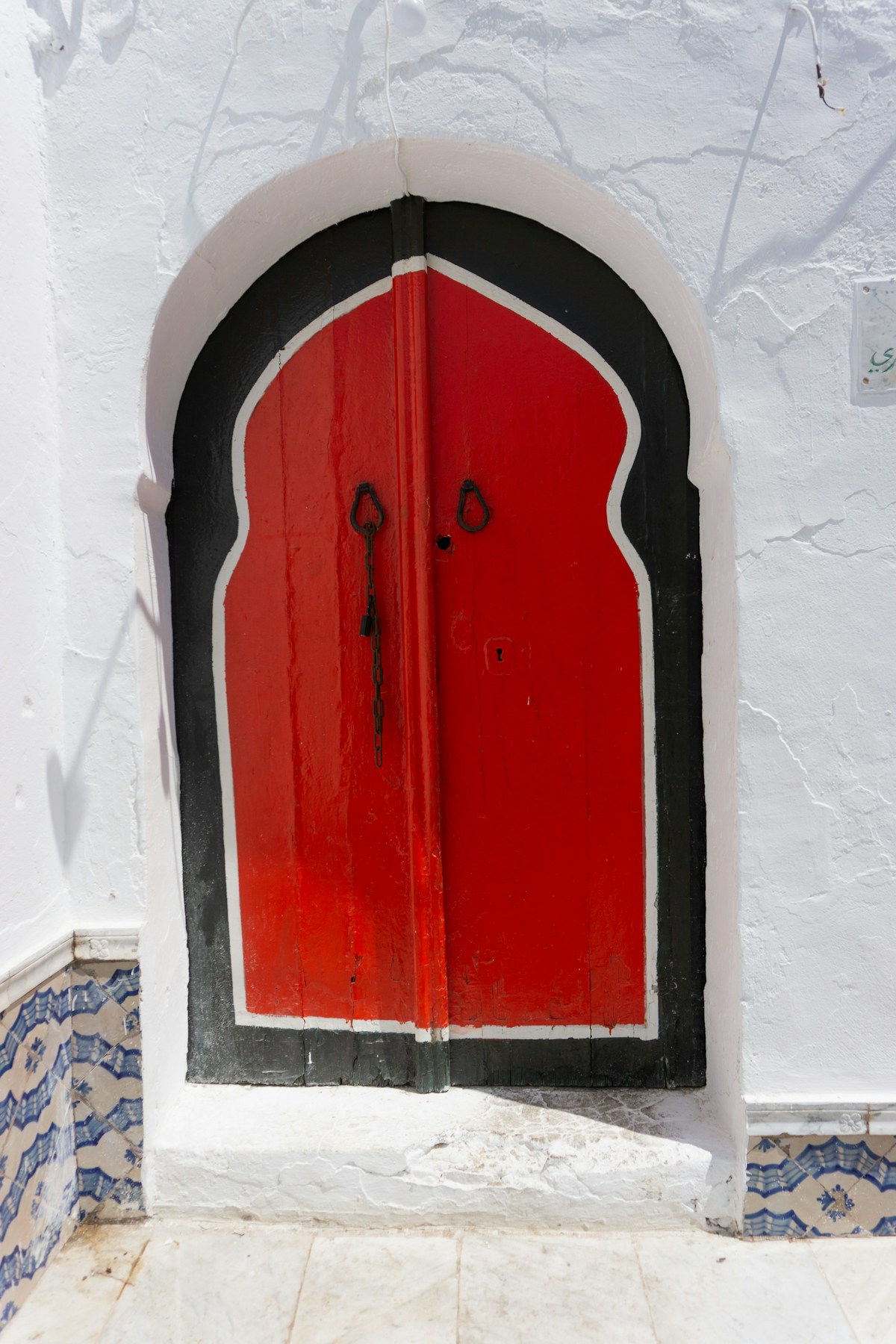 The iconic red and black door on white wall in Sidi Bou Said, Tunisia
