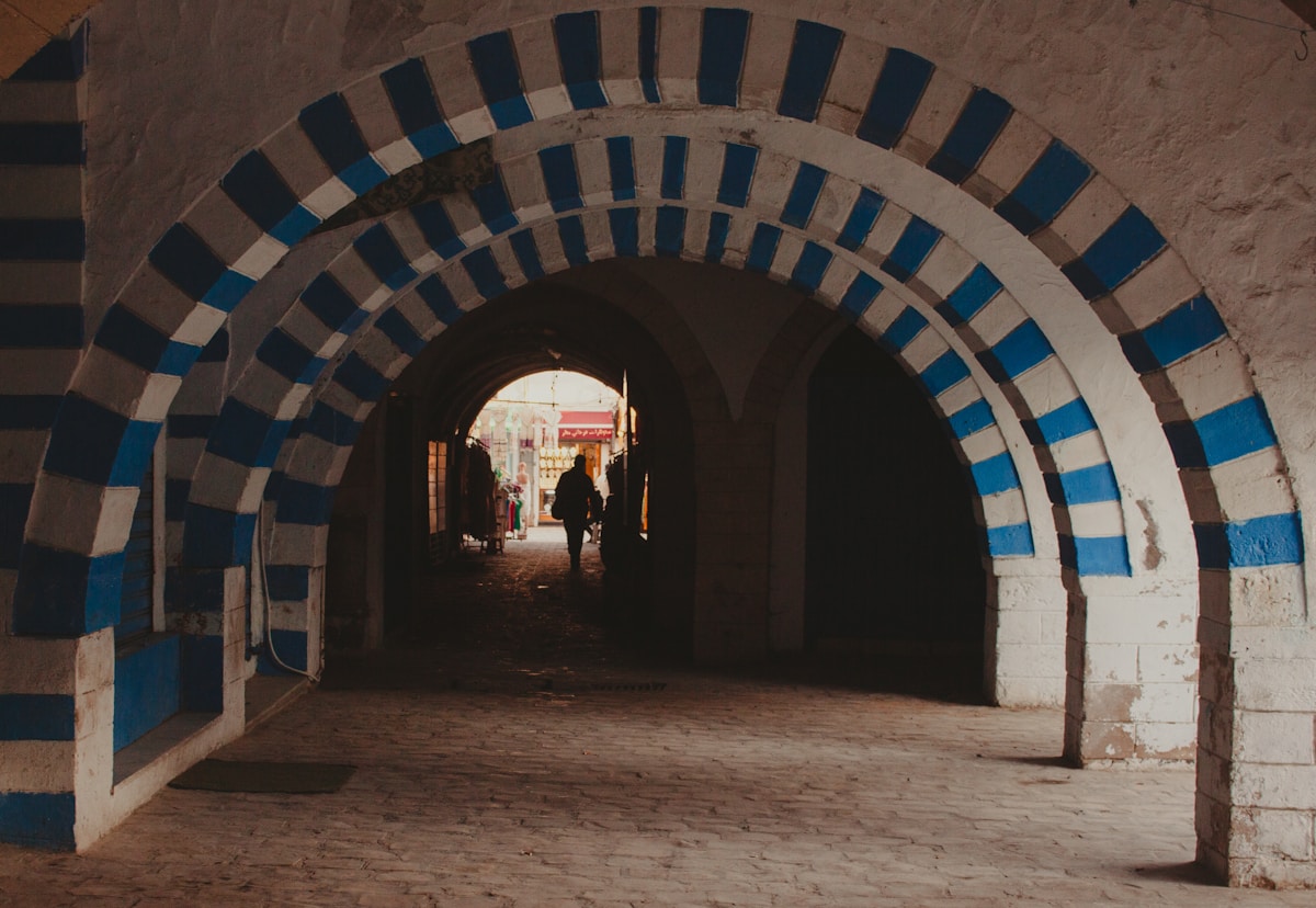 Blue and white striped arched tunnel walkway in Nabeul, Tunisia